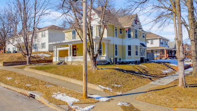 victorian-style house with central AC and a porch