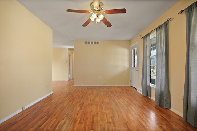 spare room with visible vents, baseboards, and wood finished floors