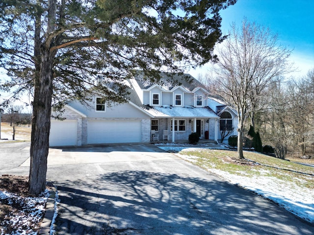 view of front of home featuring an attached garage, covered porch, and concrete driveway