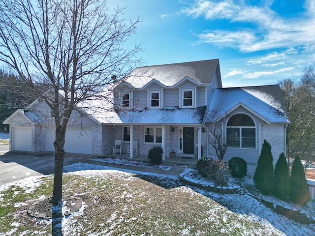 traditional home featuring concrete driveway, roof with shingles, an attached garage, a porch, and brick siding