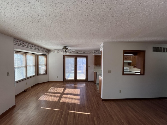 empty room with dark wood-type flooring, ceiling fan, and a textured ceiling