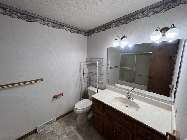 bathroom with vanity, toilet, an enclosed shower, and a textured ceiling