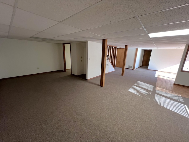 basement with a paneled ceiling and carpet flooring