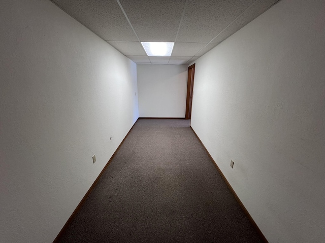 carpeted spare room featuring a drop ceiling