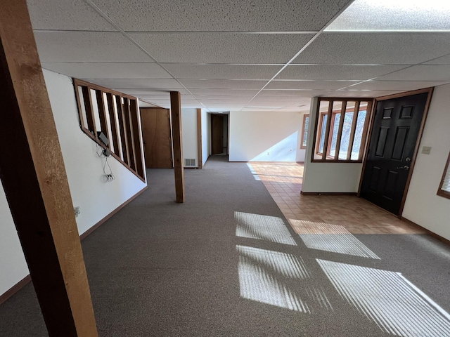 basement featuring carpet flooring and a paneled ceiling