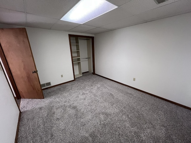 unfurnished bedroom with carpet floors and a drop ceiling