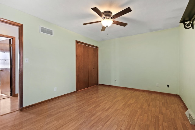 unfurnished bedroom with light hardwood / wood-style floors, a closet, and ceiling fan