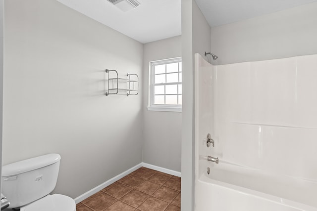 bathroom with tile patterned floors, toilet, and shower / washtub combination