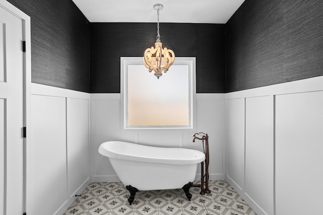 bathroom featuring an inviting chandelier and a washtub