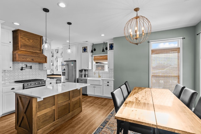 kitchen with white cabinets, custom range hood, a kitchen island, and premium appliances