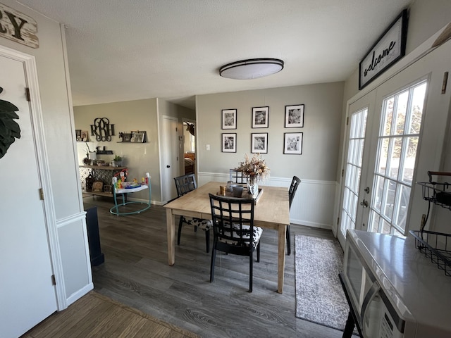 dining space featuring french doors, dark hardwood / wood-style flooring, and a textured ceiling