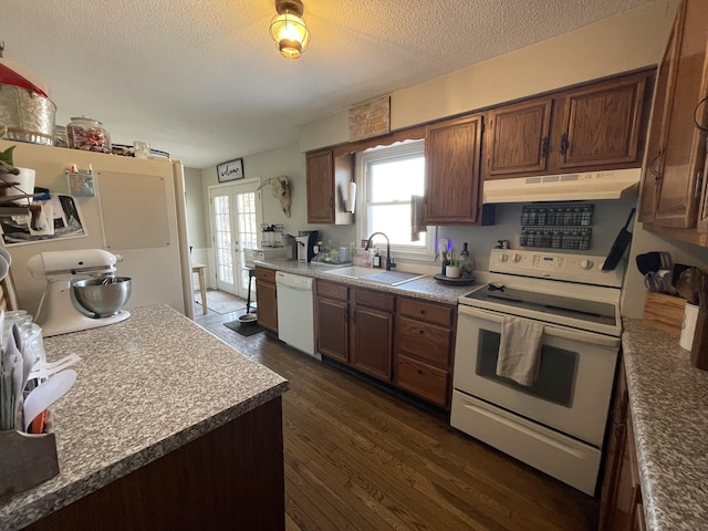 kitchen with sink, white appliances, dark wood-type flooring, a textured ceiling, and french doors