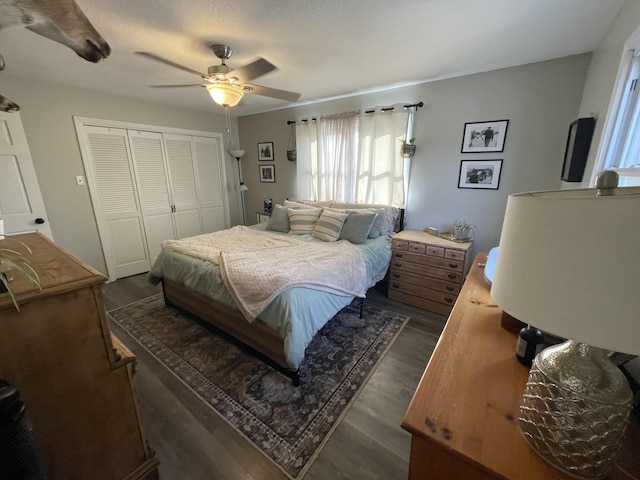 bedroom featuring dark wood-type flooring, ceiling fan, and a closet