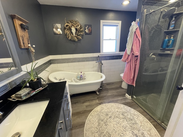 full bathroom featuring toilet, tile walls, vanity, hardwood / wood-style flooring, and plus walk in shower