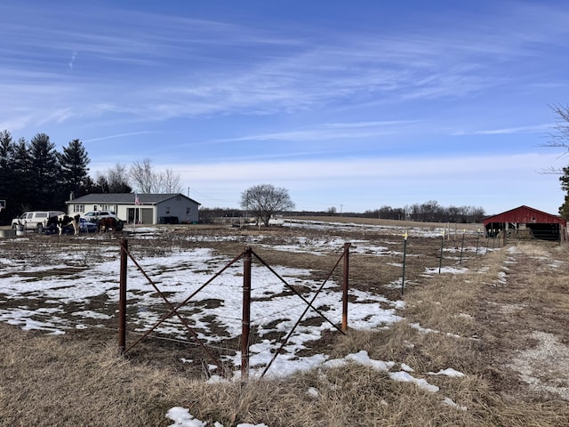 yard covered in snow with a rural view