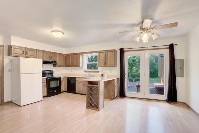 kitchen with black appliances, sink, light hardwood / wood-style floors, kitchen peninsula, and a textured ceiling