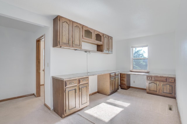 kitchen featuring light carpet and built in desk