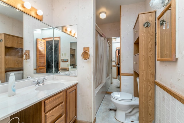 full bathroom featuring tile walls, vanity, shower / bath combination with curtain, and toilet