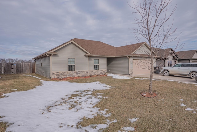 ranch-style house with a garage and a yard