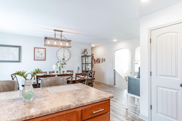 kitchen with light hardwood / wood-style flooring and decorative light fixtures