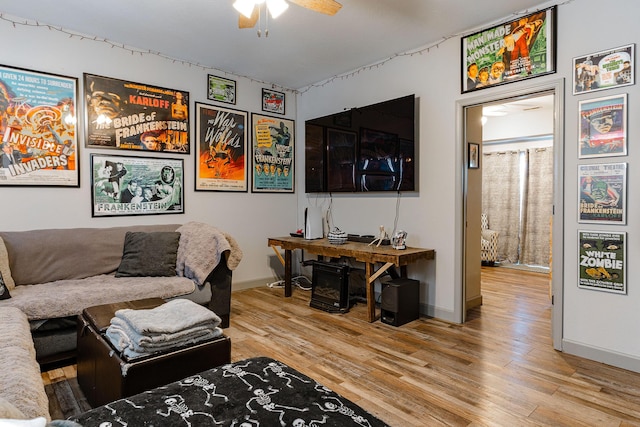 living room featuring wood-type flooring and ceiling fan