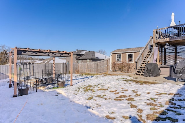 yard covered in snow featuring a deck and a pergola