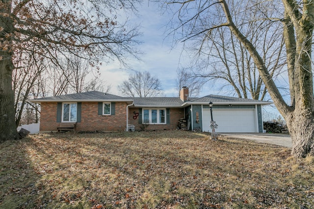 ranch-style home featuring a garage, driveway, brick siding, and a chimney