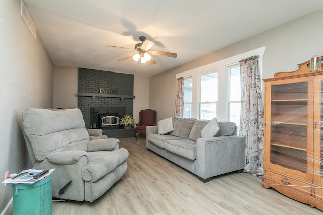 living room with visible vents, light wood-style flooring, and ceiling fan