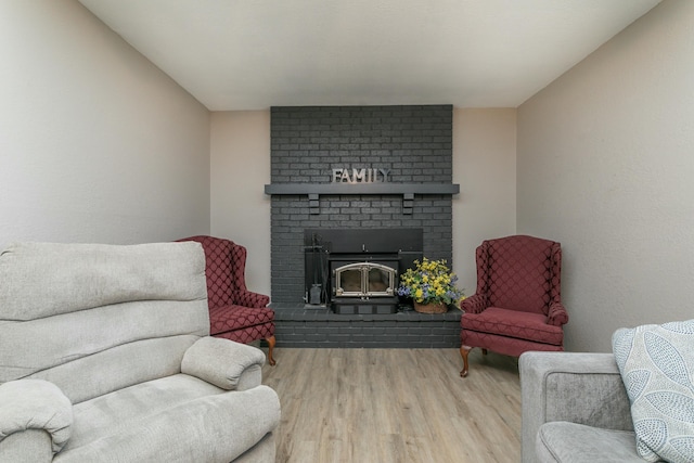 living room with wood-type flooring and a brick fireplace