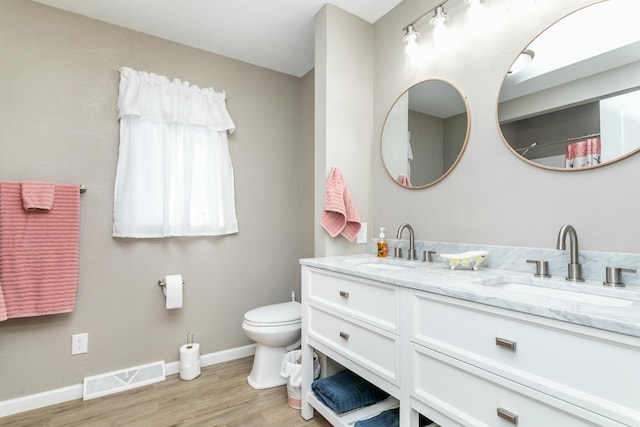 bathroom featuring wood-type flooring, vanity, and toilet