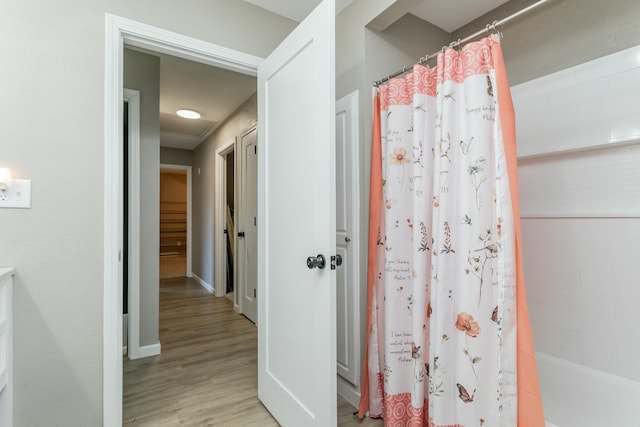 bathroom featuring wood-type flooring and shower / tub combo