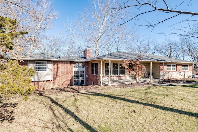 back of house with a patio area and a lawn