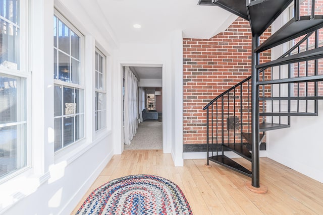 interior space featuring light hardwood / wood-style flooring and brick wall