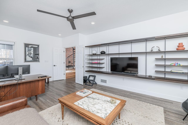 living room featuring dark hardwood / wood-style flooring and ceiling fan