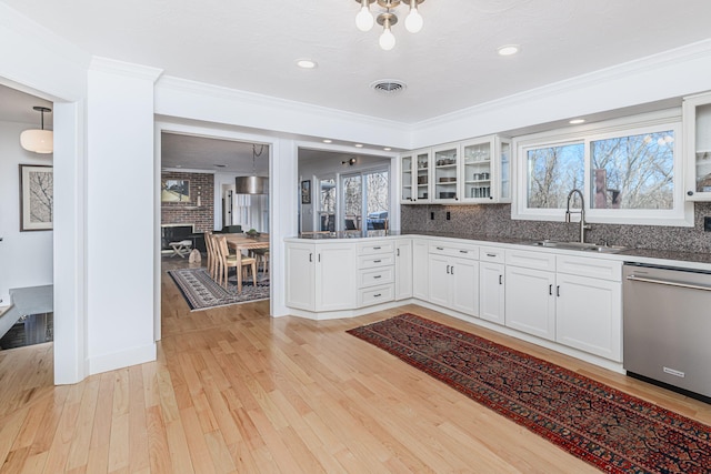 kitchen with sink, stainless steel dishwasher, pendant lighting, light hardwood / wood-style floors, and white cabinets