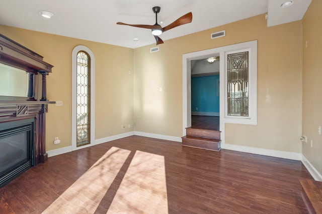 unfurnished living room with ceiling fan and dark hardwood / wood-style flooring