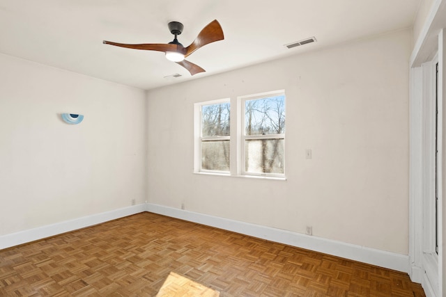 empty room with ceiling fan and light parquet floors