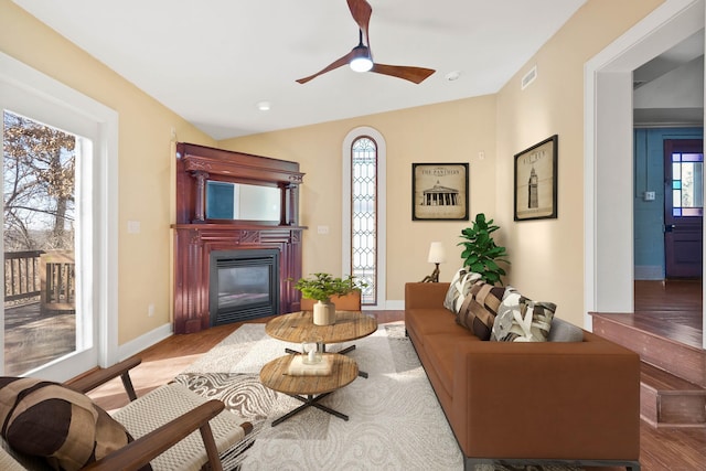 living room with lofted ceiling, hardwood / wood-style floors, a healthy amount of sunlight, and ceiling fan