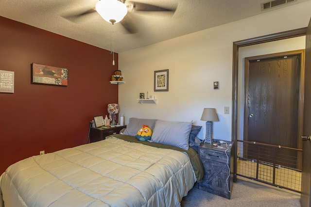 carpeted bedroom featuring a textured ceiling and ceiling fan