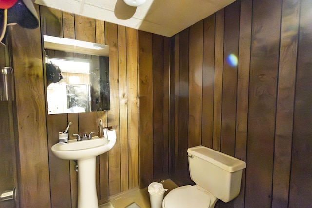 bathroom featuring toilet and wooden walls