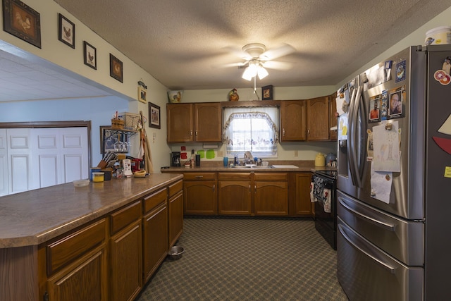 kitchen with stainless steel refrigerator with ice dispenser, sink, black electric range, a textured ceiling, and ceiling fan