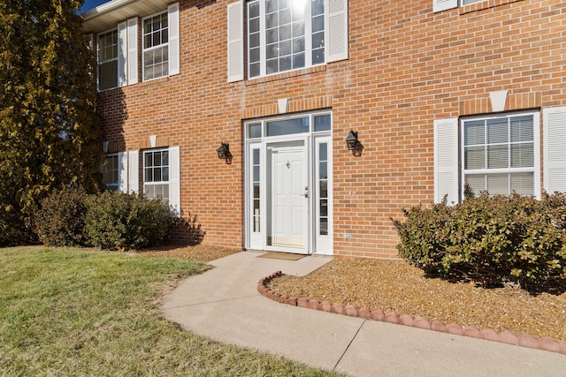 view of exterior entry featuring a lawn