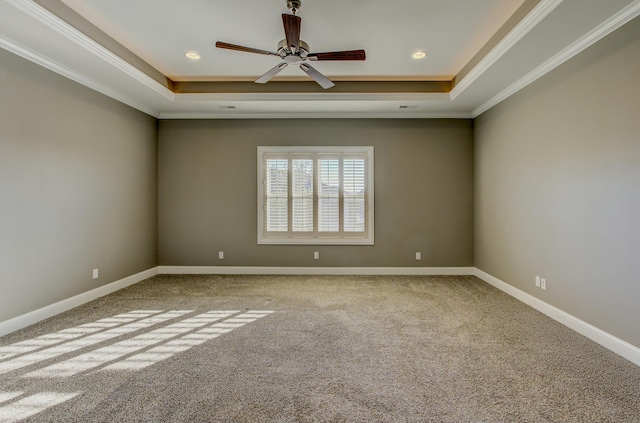 spare room with a tray ceiling, ornamental molding, ceiling fan, and carpet flooring