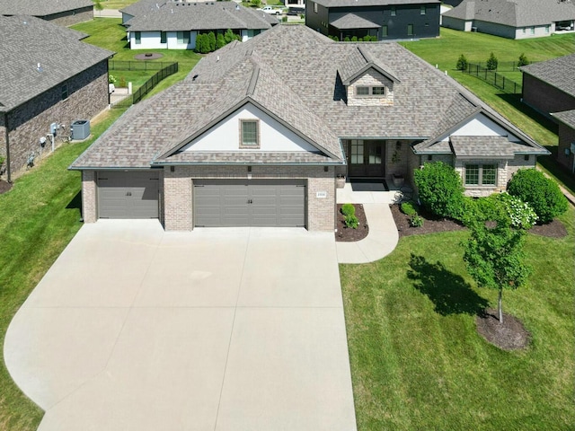 view of front facade featuring a garage, central AC, and a front lawn