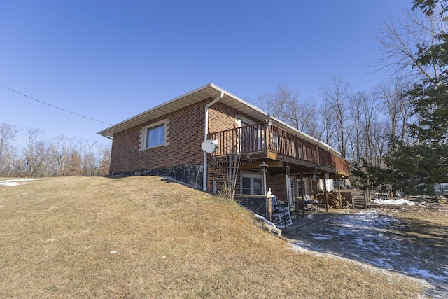 view of side of home featuring a deck and a lawn