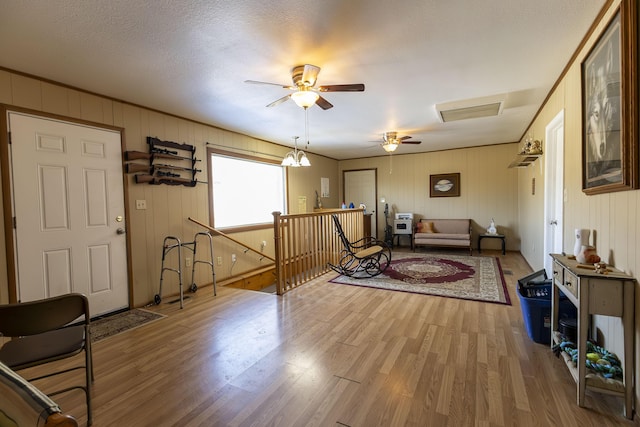 living room with hardwood / wood-style floors, a textured ceiling, and ceiling fan