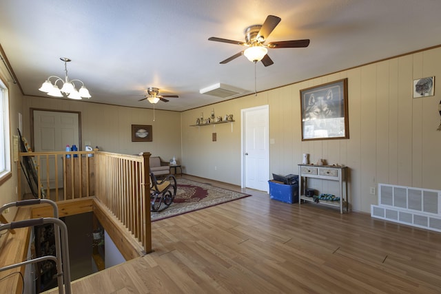 interior space featuring hardwood / wood-style floors, an inviting chandelier, and wood walls