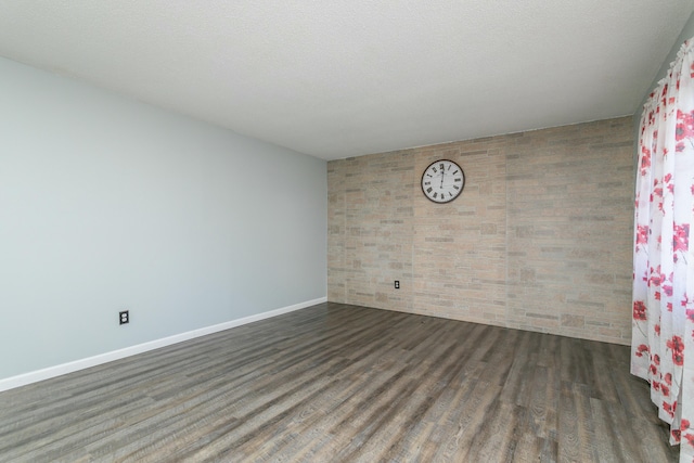 unfurnished room featuring dark hardwood / wood-style floors and a textured ceiling