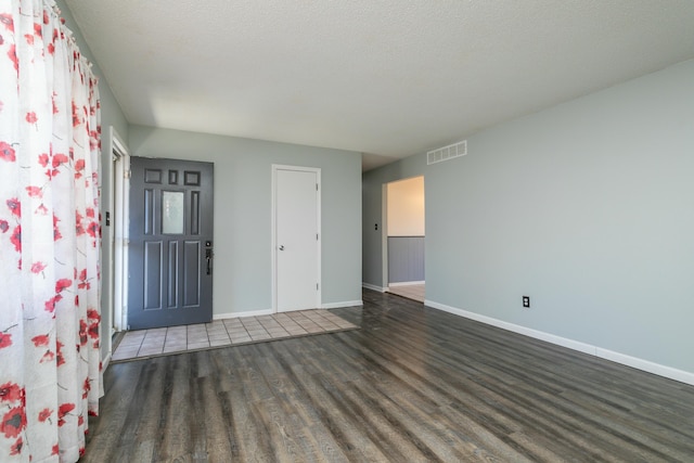 spare room with dark wood-type flooring and a textured ceiling