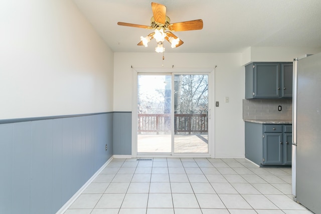 unfurnished dining area featuring light tile patterned floors and ceiling fan